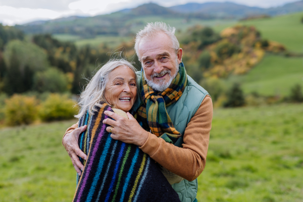 Senior couple in love huging each other in autumn forest.