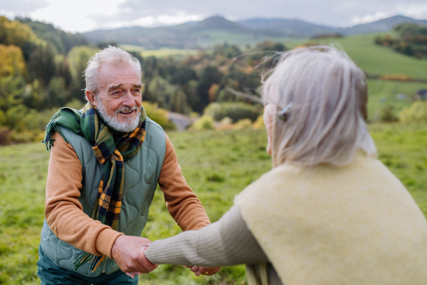 Happy senior couple walking in autumn nature.