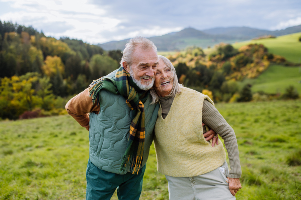 Happy senior couple walking in autumn nature.