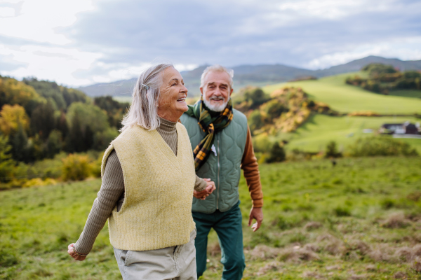 Happy senior couple walking in autumn nature.