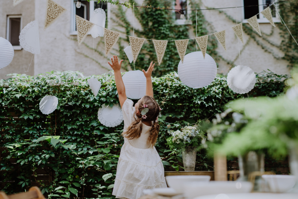 Rear view of happy little child playing with a wedding decorations.