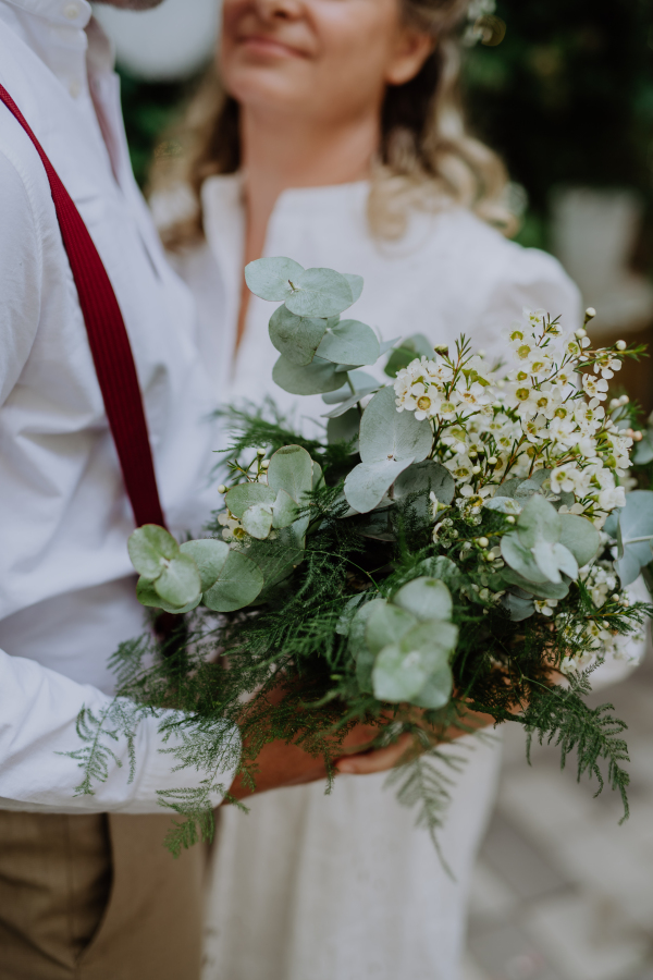 Close-up of a wedding bouquet holding groom and wife.