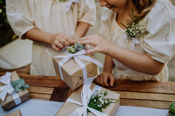 Little girls preparing gift for bride at a wedding garden party.