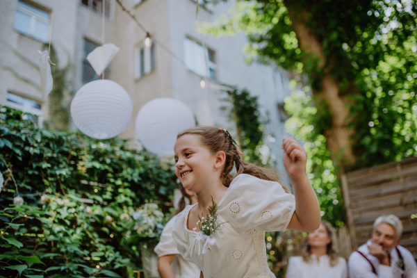 Little girl having fun at an outdoor wedding party.