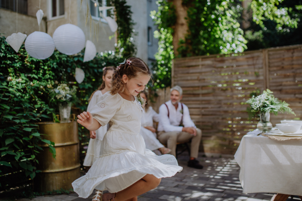 Little child dancing and enjoying an outdoor wedding party of her parents.