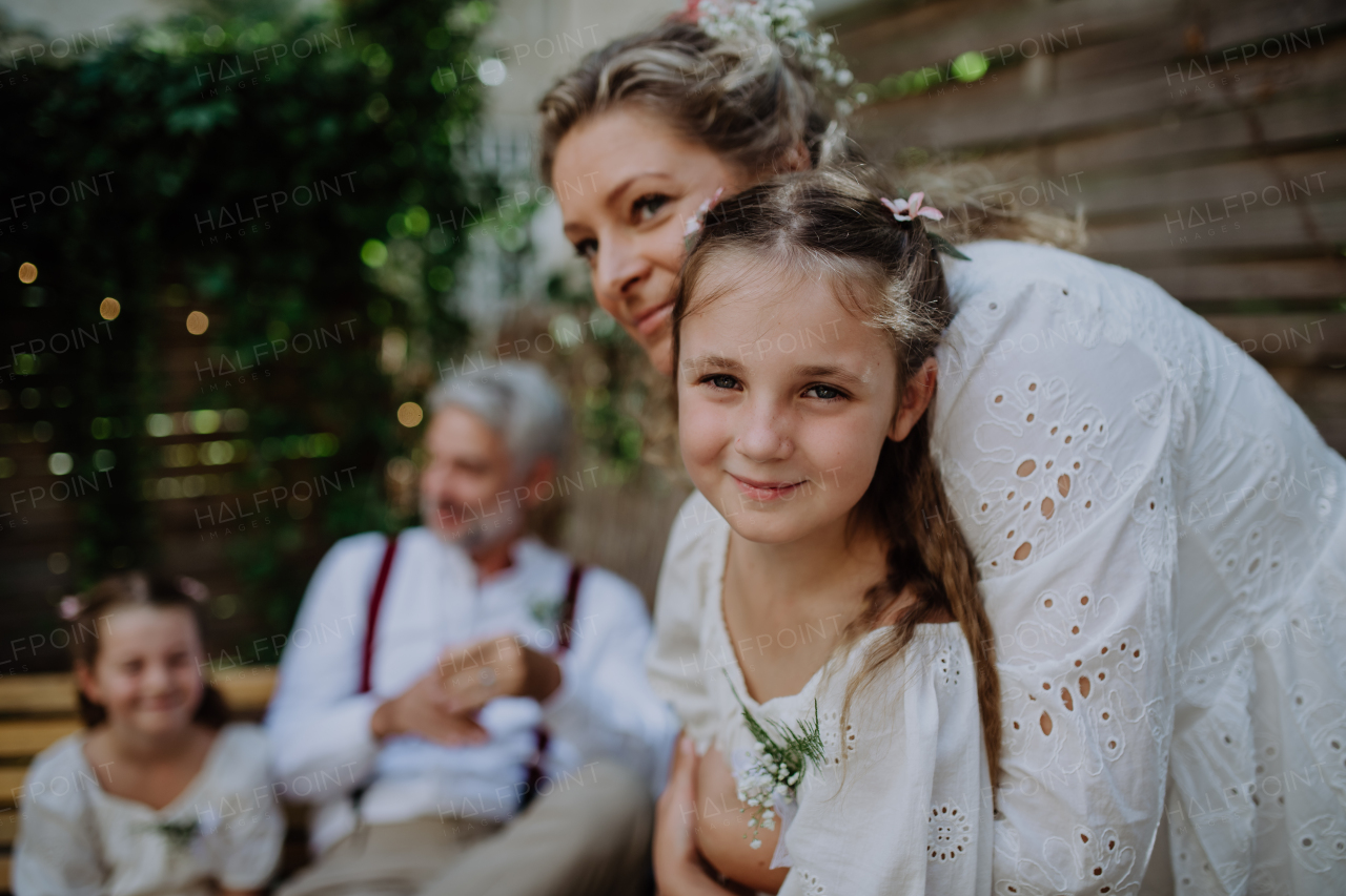 A mature bride and groom receiving congratulations after at wedding reception outside in the backyard.