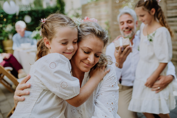 A mature bride and groom receiving congratulations after at wedding reception outside in the backyard.