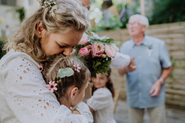 Bride receiving congratulations by girls at outdoor wedding party.