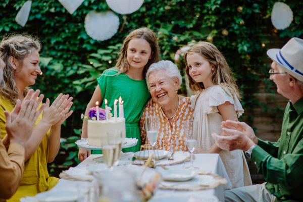 A multi-generation family on outdoor summer garden party, celebrating birthday