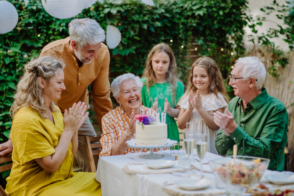 A multi-generation family on outdoor summer garden party, celebrating birthday