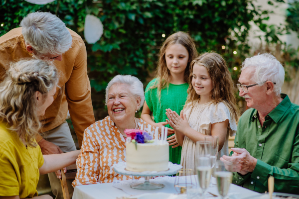 A multi-generation family on outdoor summer garden party, celebrating birthday