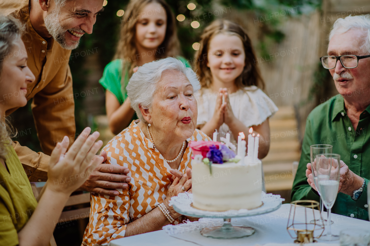 A multi-generation family on outdoor summer garden party, celebrating birthday