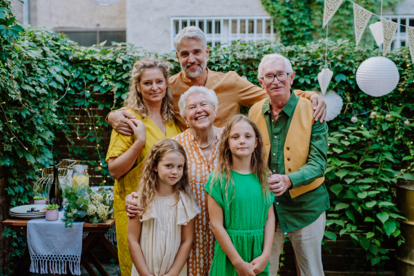 A multi-generation family on outdoor summer garden party, celebrating birthday