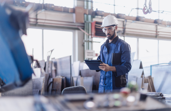 An engineering manager and mechanic worker doing routine check up in industrial factory