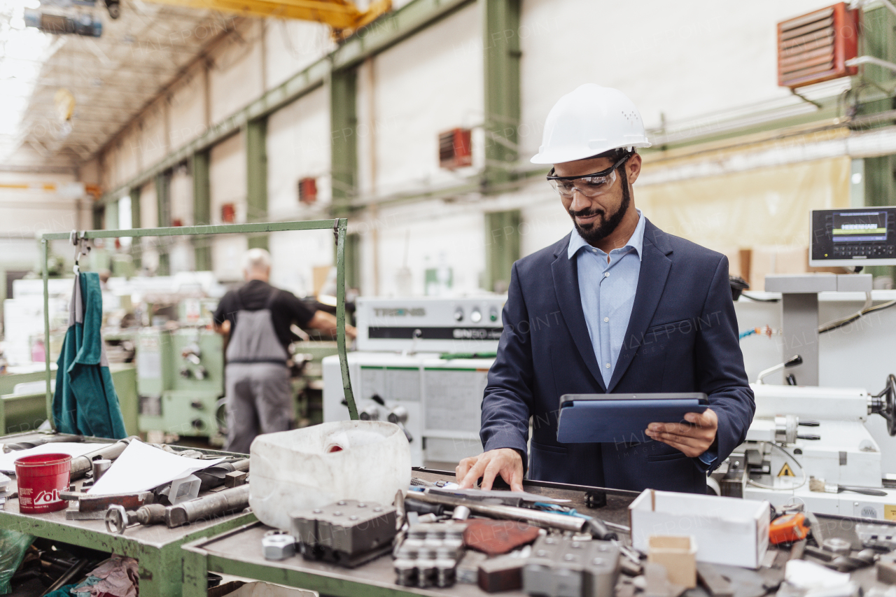 An engineering manager and mechanic worker doing routine check up in industrial factory