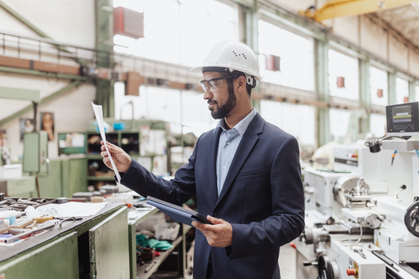 An engineering manager and mechanic worker doing routine check up in industrial factory