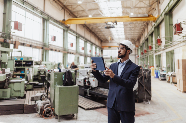 An engineering manager and mechanic worker doing routine check up in industrial factory