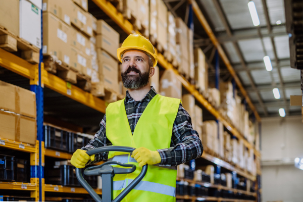 Male warehouse worker pushing the pallet truck.