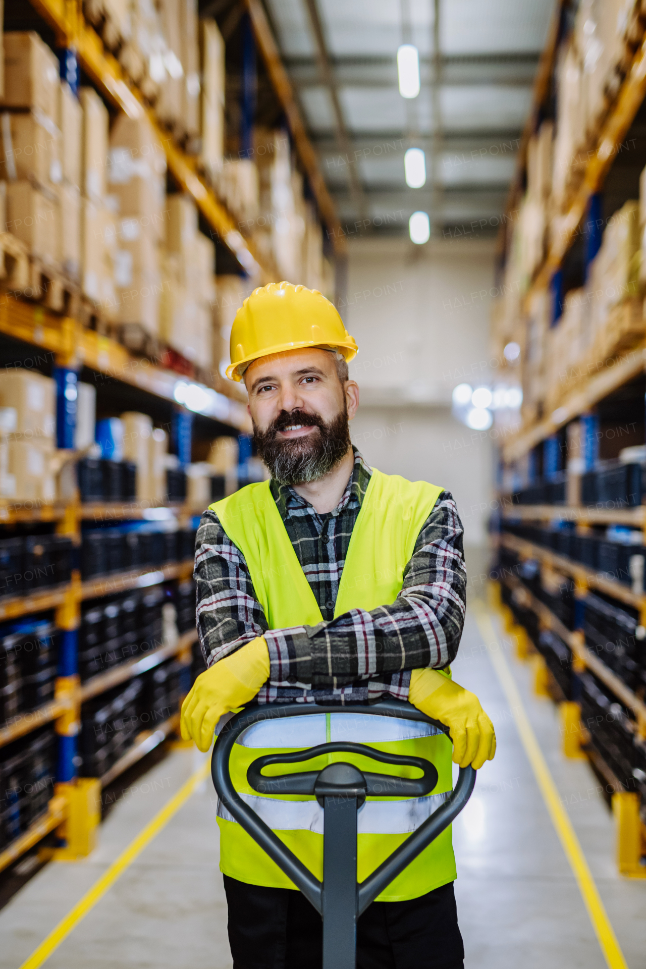 Male warehouse worker pushing the pallet truck.