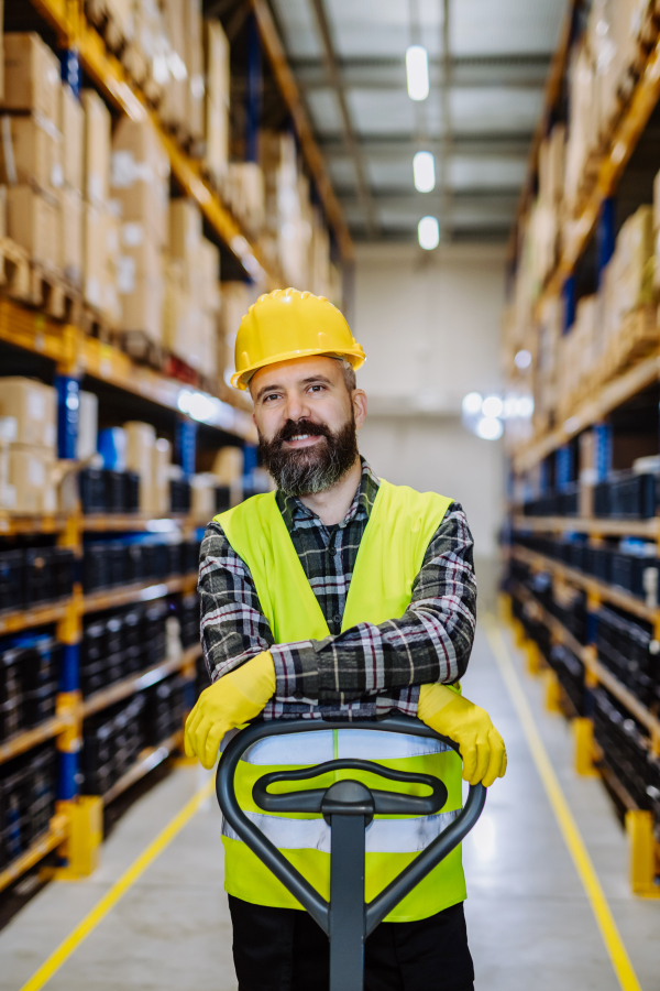 Male warehouse worker pushing the pallet truck.