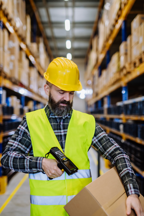 Warehouse worker stocking goods in warehouse.