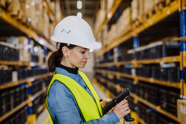 Warehouse female worker checking up stuff in warehouse.