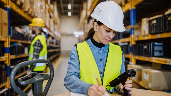 Warehouse workers checking stuff in a warehouse with digital system.