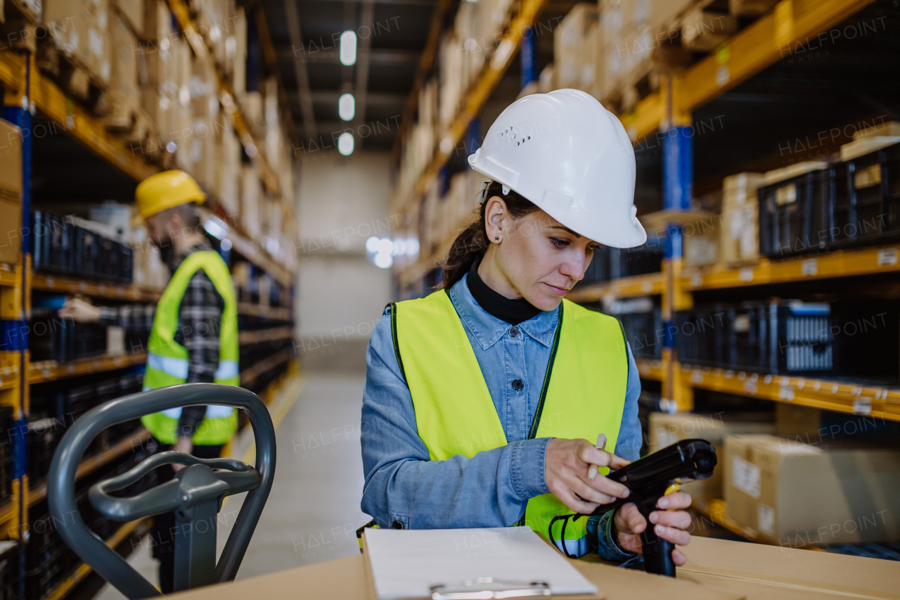 Warehouse female worker checking up stuff in warehouse.