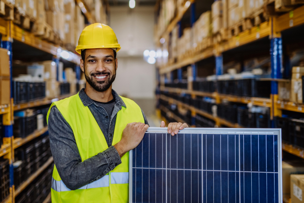 Portrait of warehouse worker with a solar panel.