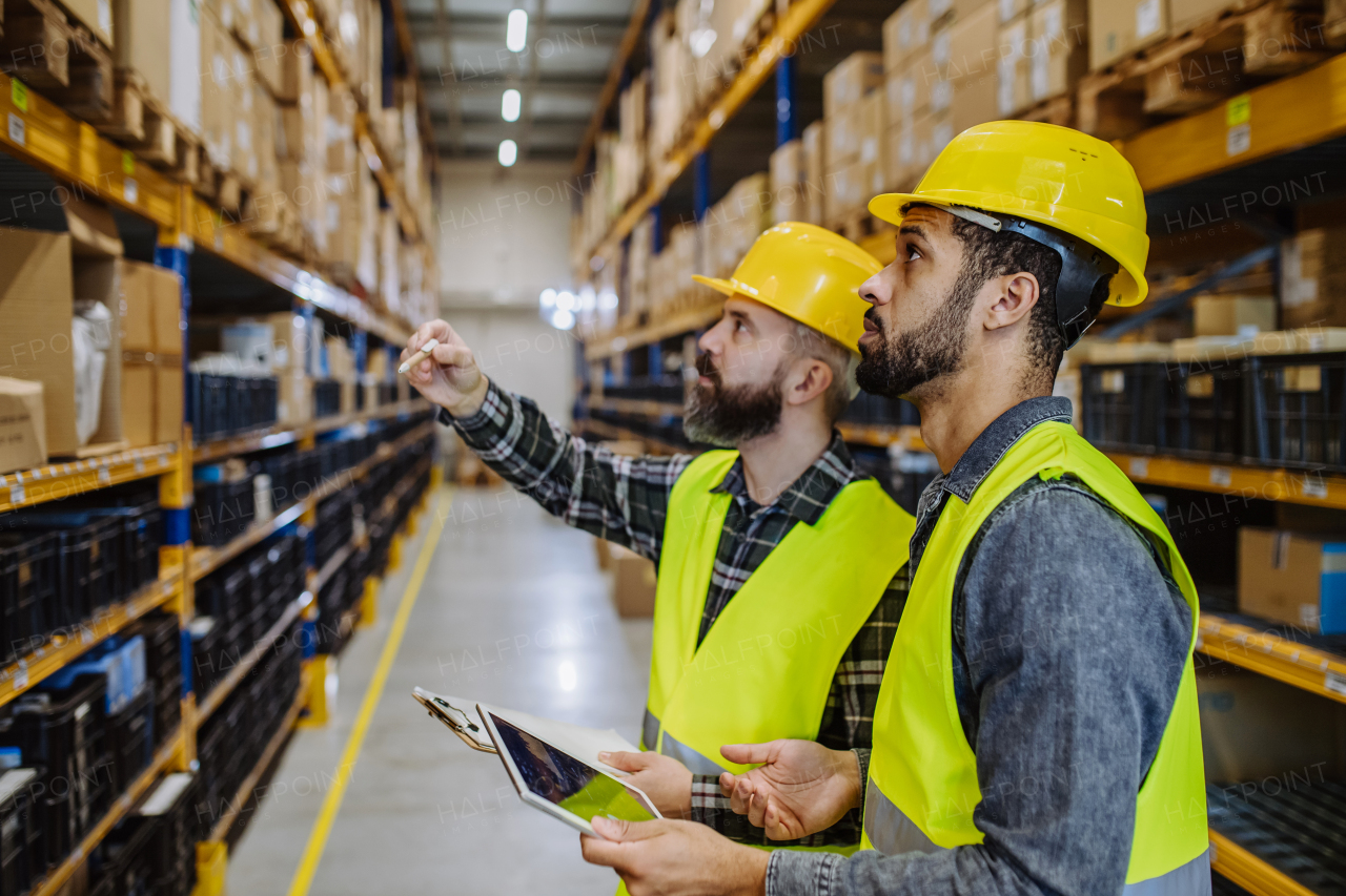 Warehouse workers checking stuff in warehouse with digital system in a tablet.