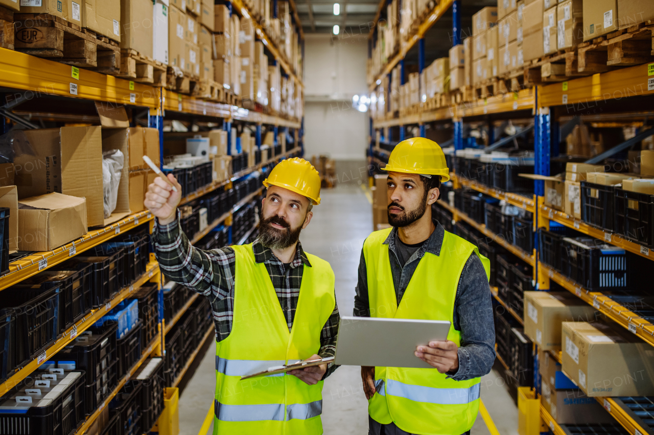 Warehouse workers checking stuff in warehouse with digital system in a tablet.