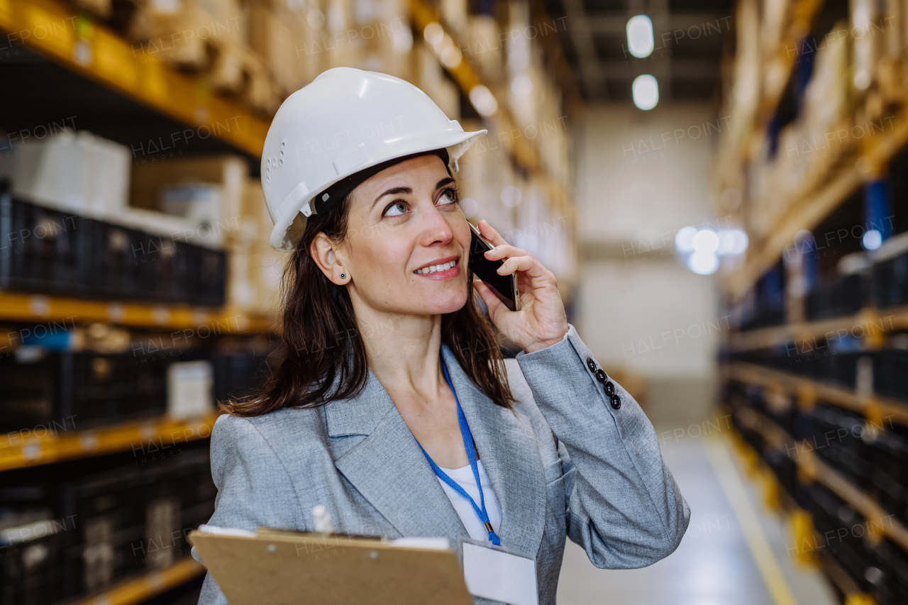 Manager woman in suit calling in warehouse.