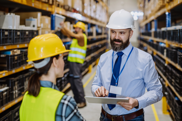 Manager explaining work to his employers in a warehouse.