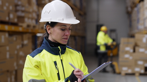 Warehouse female worker checking up stuff in warehouse.