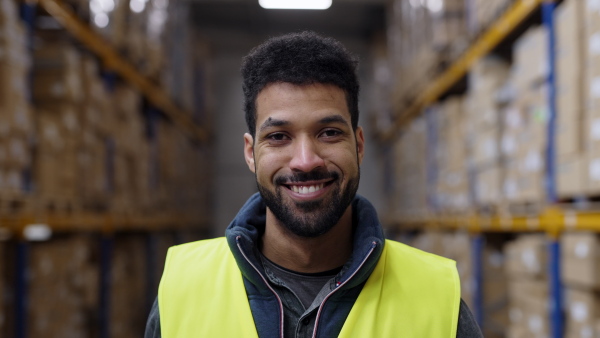 Video of a male warehouse worker or a supervisor walking towards the camera.