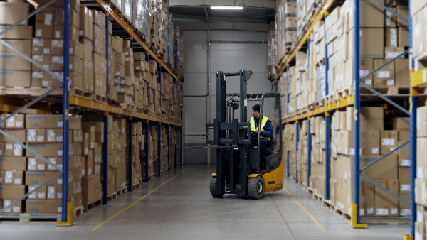 Male warehouse worker using a fork lift.