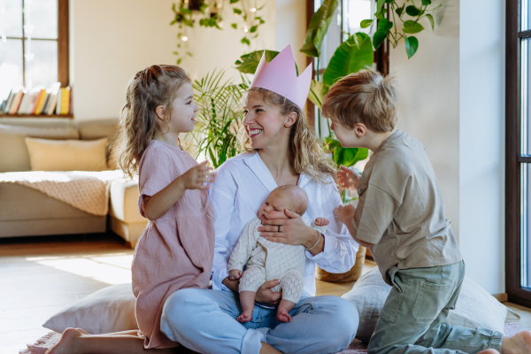 Mother after giving birth as a queen. Daughter giving mom a paper crown and admiration, love for mothers, concept of Mother's Day and women's strength.