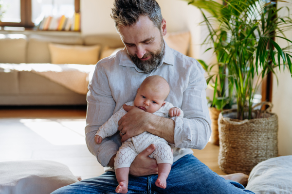 Father holding his newborn baby. Unconditional paternal love and Father's Day concept.