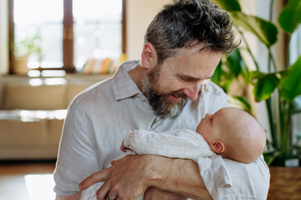 Father holding his newborn baby. Unconditional paternal love and Father's Day concept.