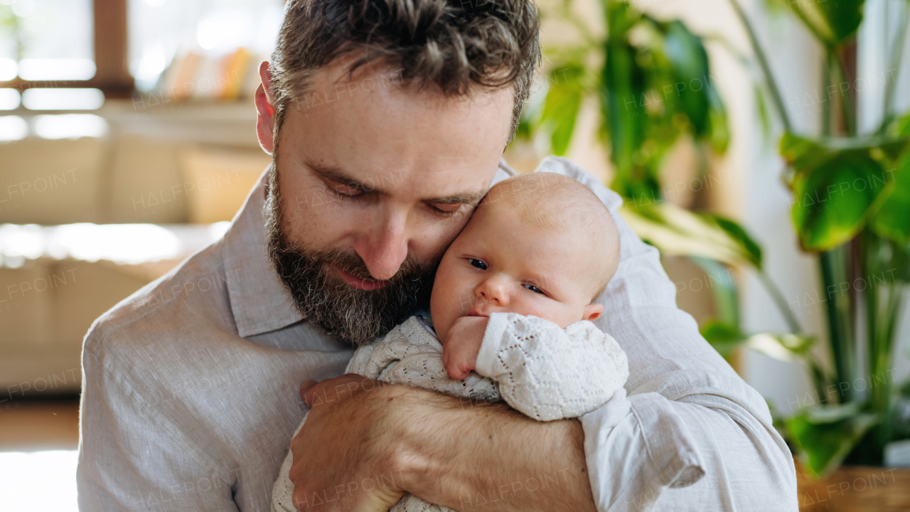 Father holding his newborn baby. Unconditional paternal love and Father's Day concept.