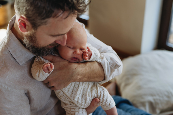 Father holding his newborn baby. Unconditional paternal love and Father's Day concept.