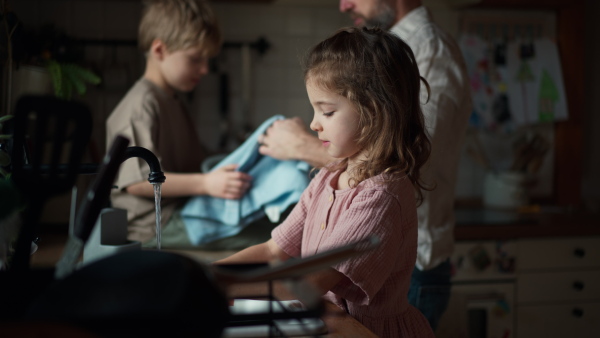 Dad and daughter cooking together in kitchen, cleaning fruit in sink. Girls dad. Unconditional paternal love and Father's Day concept.