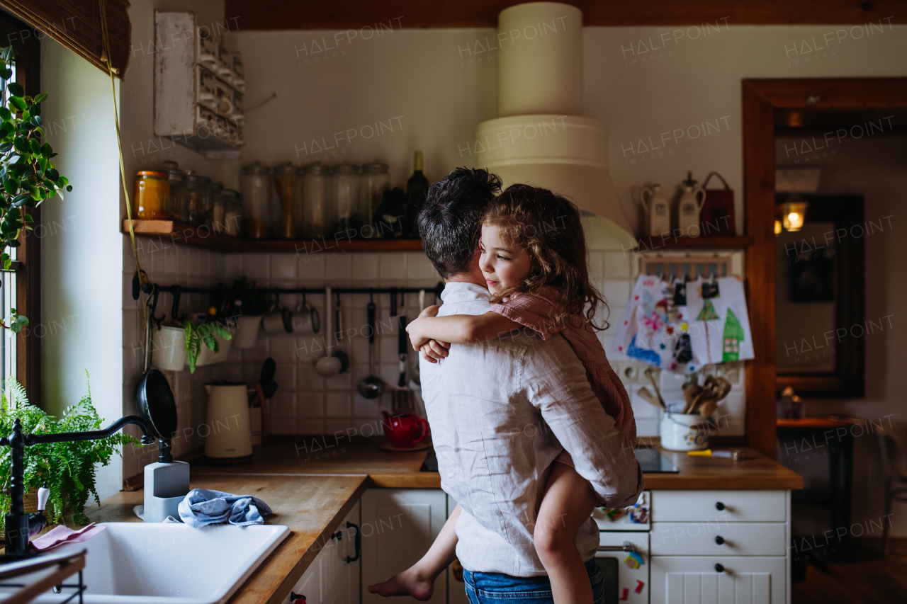 Daughter hugging father lovingly, looking at camera, smiling with gap toothed grin. Unconditional paternal love, Father's Day concept.