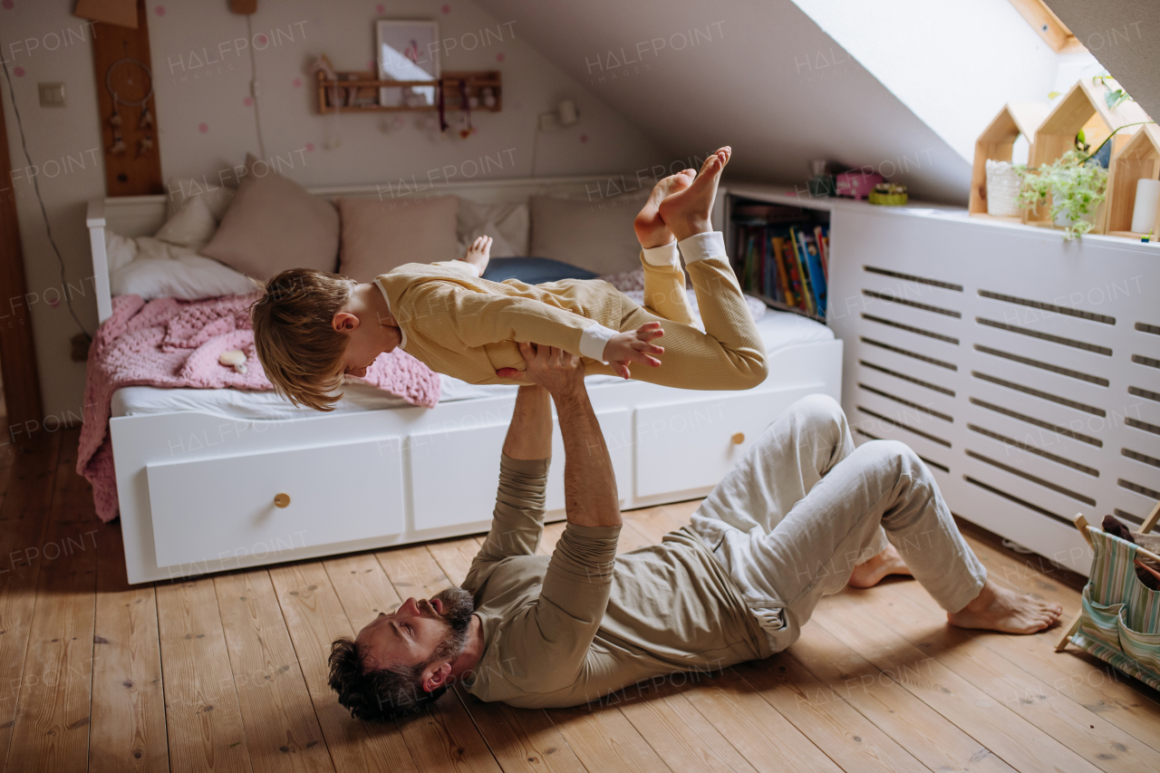 Father an son doing ariplane game, lifting boy up with hands like plane and aughing together. Boys dad. Unconditional paternal love, Father's Day concept.