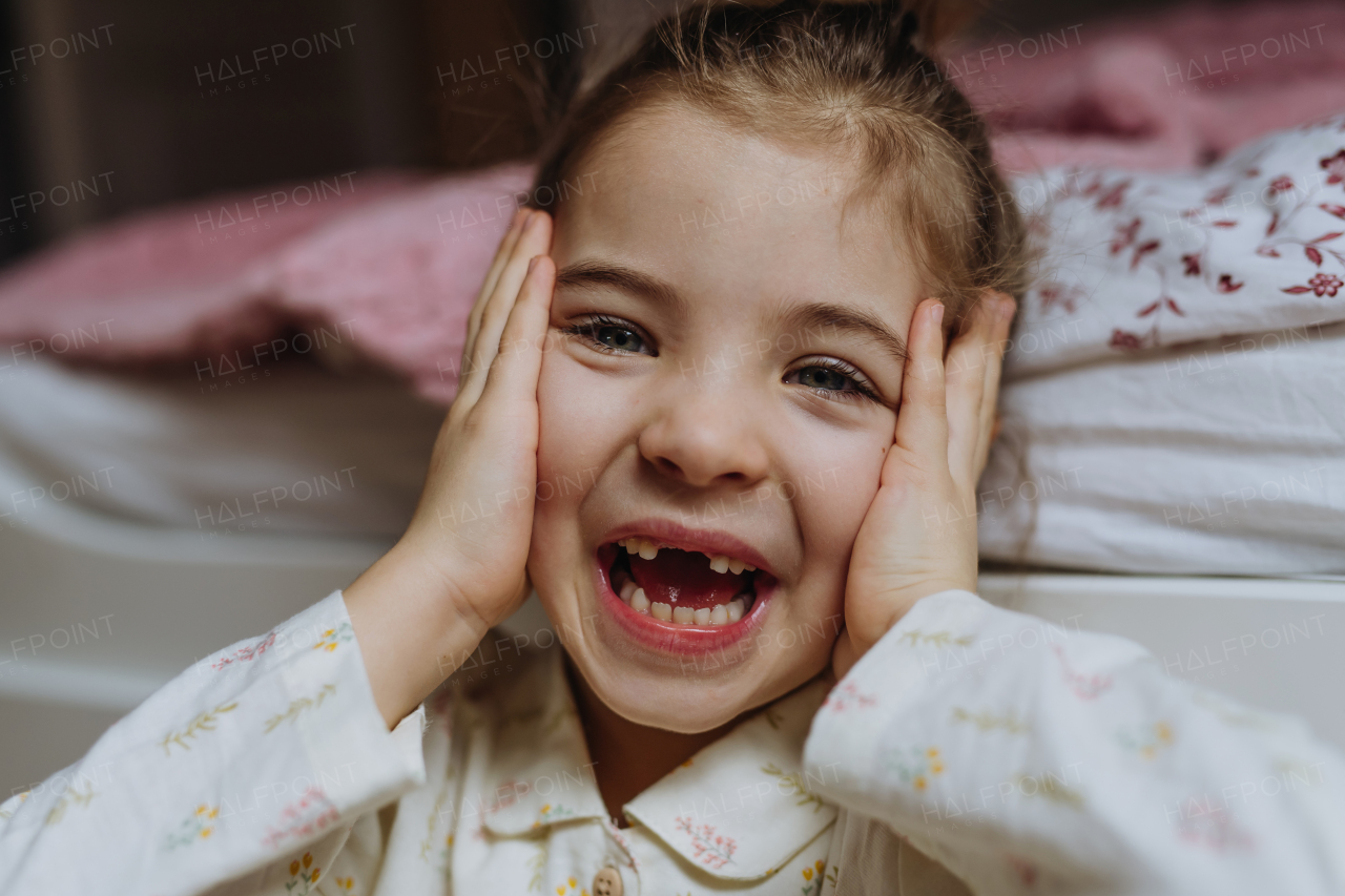 Portrait of cute girl smiling with a gap-toothed grin, missing her top front baby teeth.