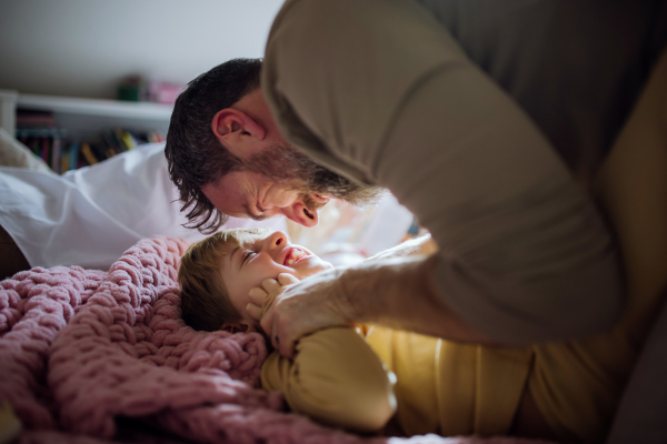 Father an son playing, tickling and laughing together. Boys dad. Unconditional paternal love, Father's Day concept.