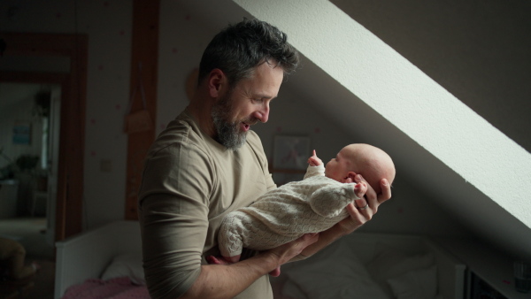 Father holding his newborn baby. Unconditional paternal love and Father's Day concept.