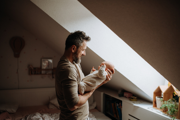 Father holding his newborn baby. Unconditional paternal love and Father's Day concept.