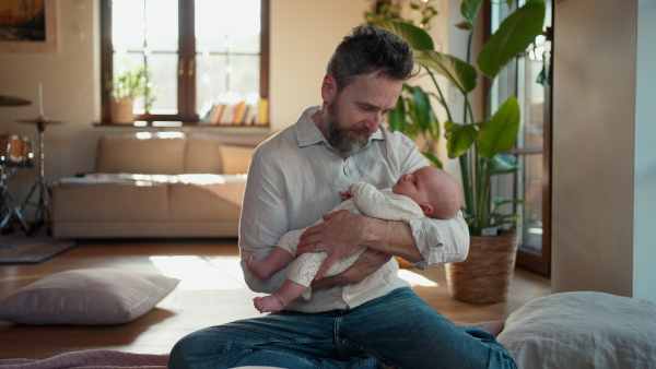 Father holding his newborn baby. Unconditional paternal love and Father's Day concept.