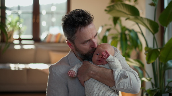 Father holding his newborn baby. Unconditional paternal love and Father's Day concept.